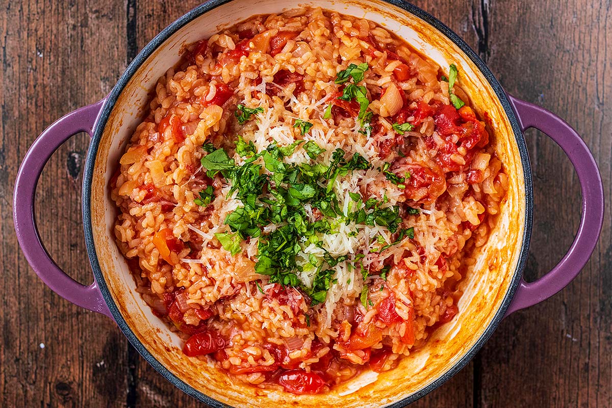 Baked risotto with grated Parmesan and chopped basil on it.