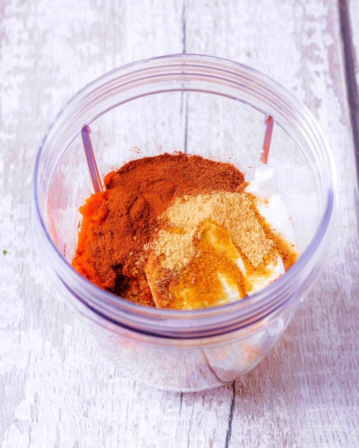 Yogurts, spices and maple syrup in a blender jug.