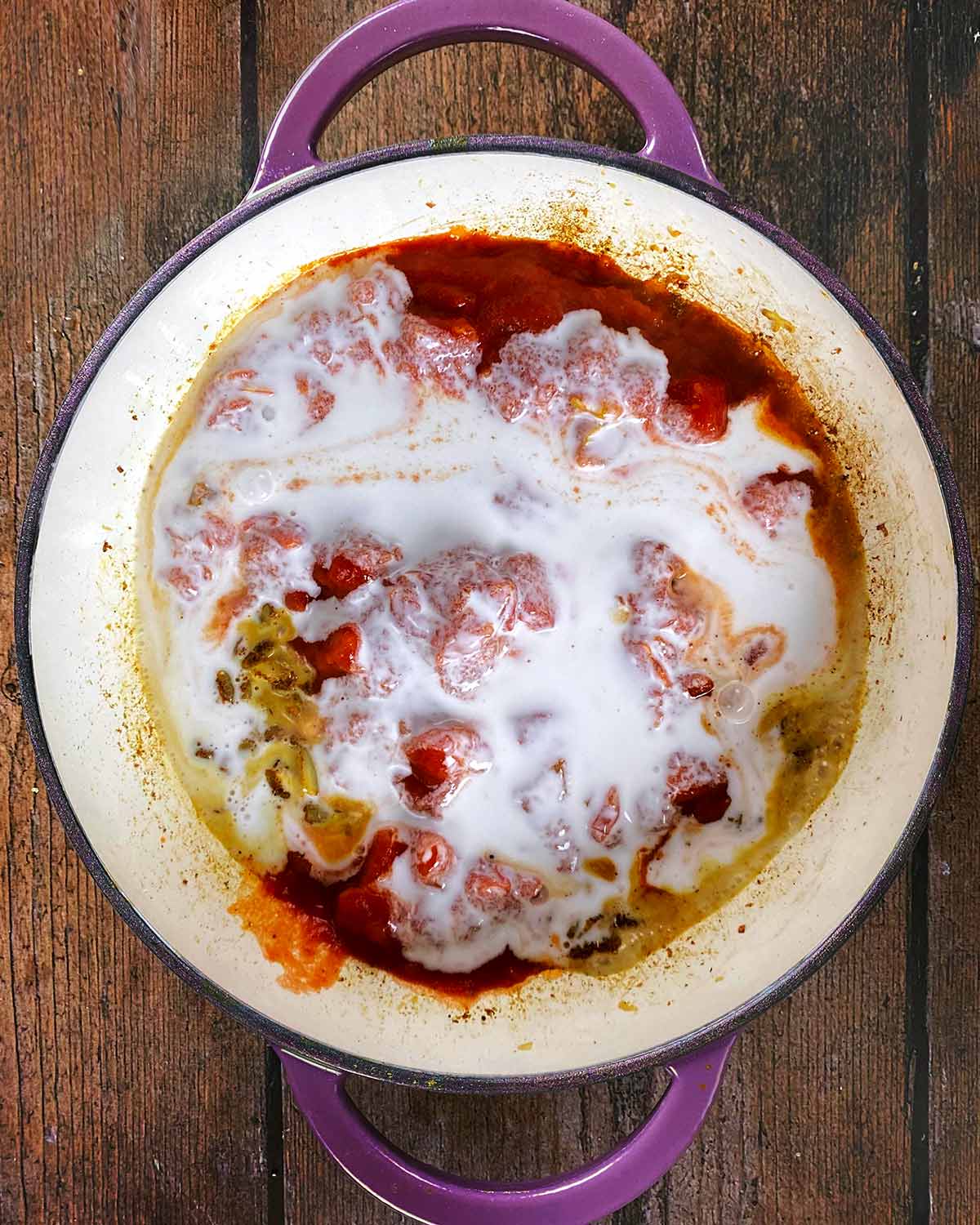 Chopped tomatoes and coconut milk added to the pan.