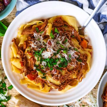 Slow cooker beef ragu in a bowl with a fork.