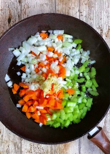 Chopped vegetables cooking in a frying pan.