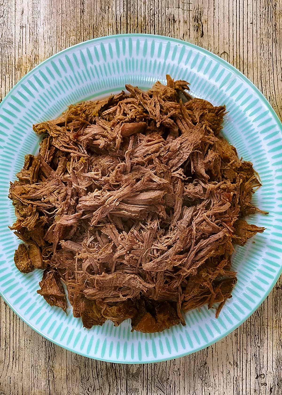 Shredded cooked beef on a plate.