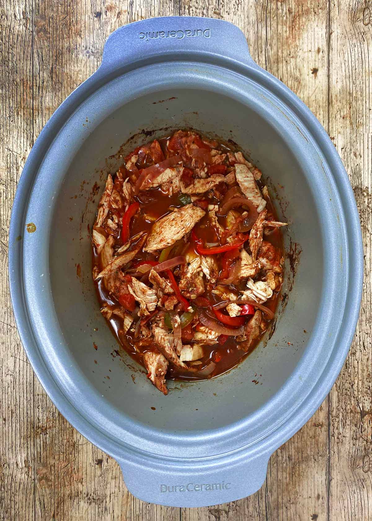 Cooked chicken fajita mix in a slow cooker.