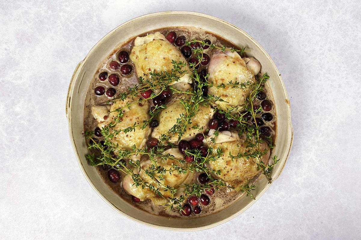 Whole cranberries and sprigs of thyme added to the chicken.