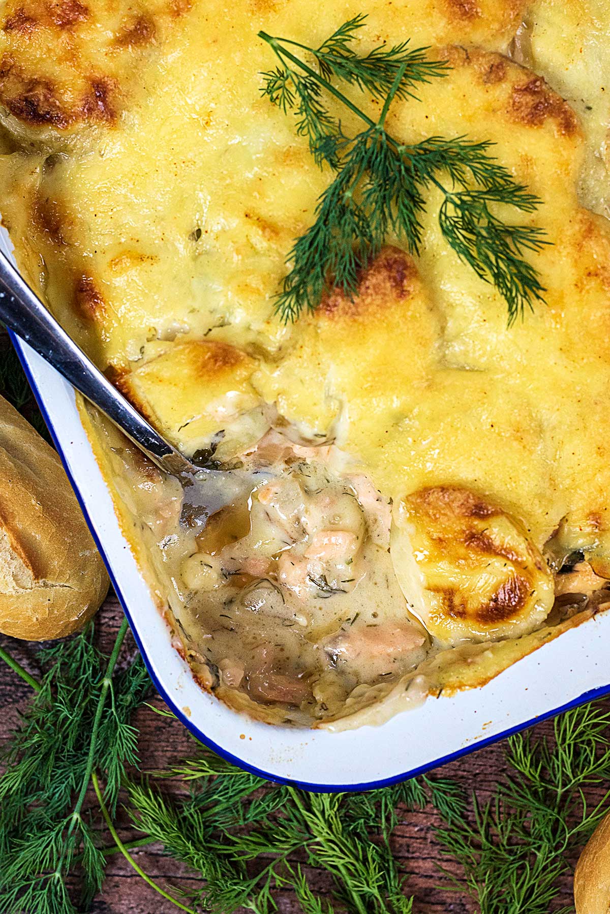 Salmon casserole in a baking tray with a section spooned out revealing the filling.