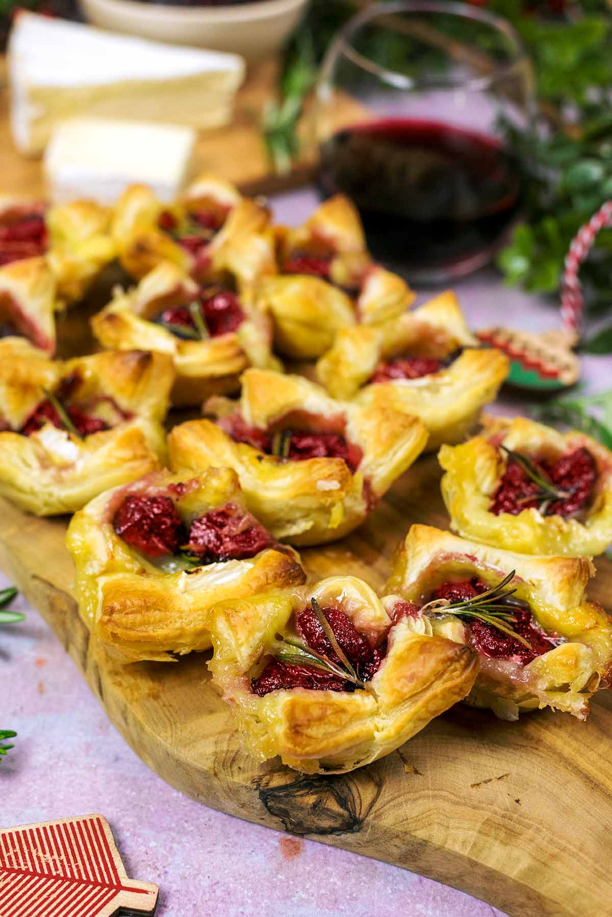 Puff pastry cranberry bites on a wooden serving board.