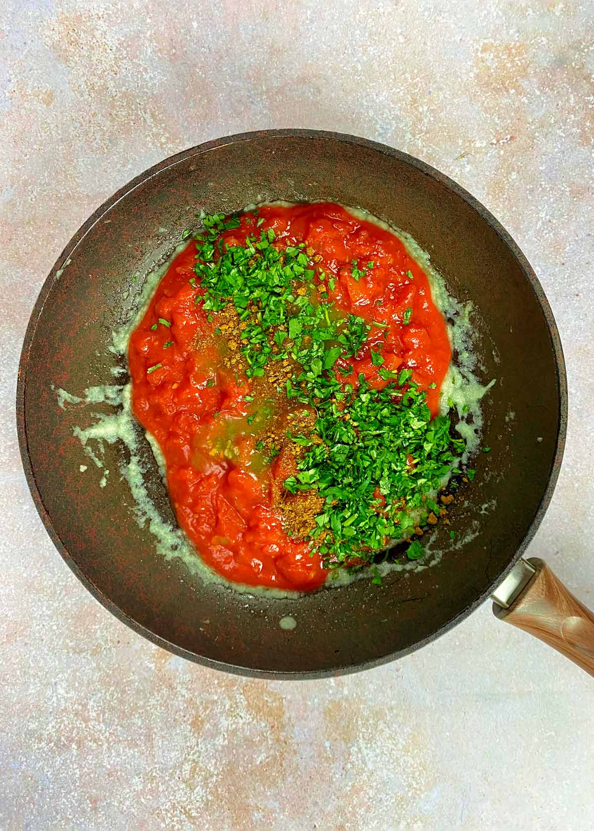 Chopped tomatoes, spice blend and chopped coriander added to the onion paste.