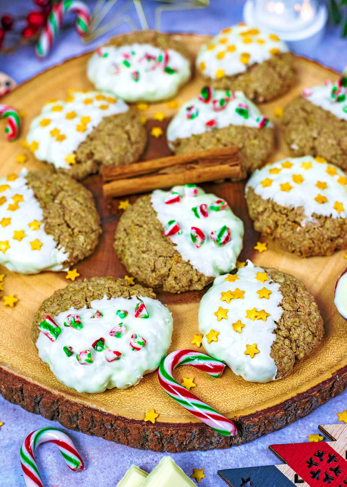 Decorated cookies on a wooden board with cinnamon sticks.