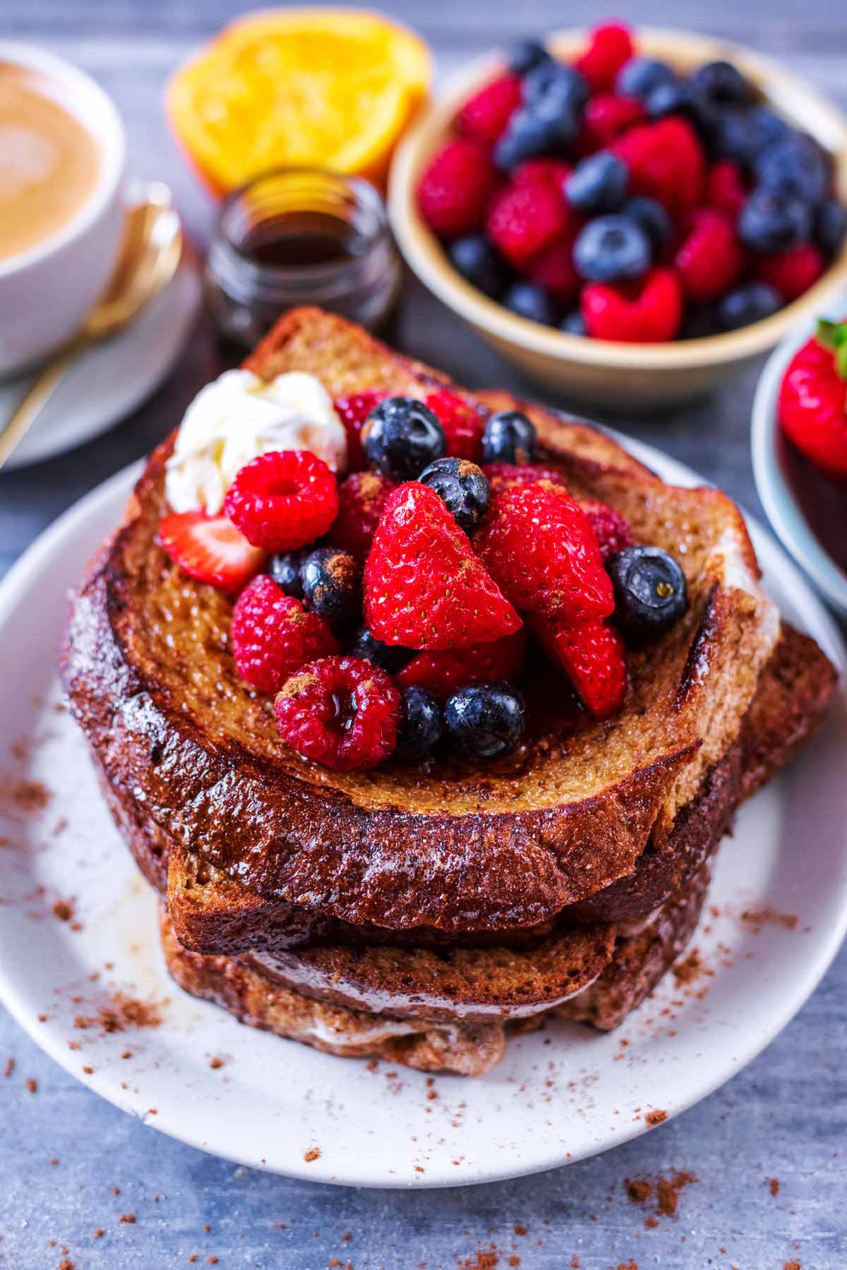 A stack of french toast topped with berries and a dollop of yogurt.