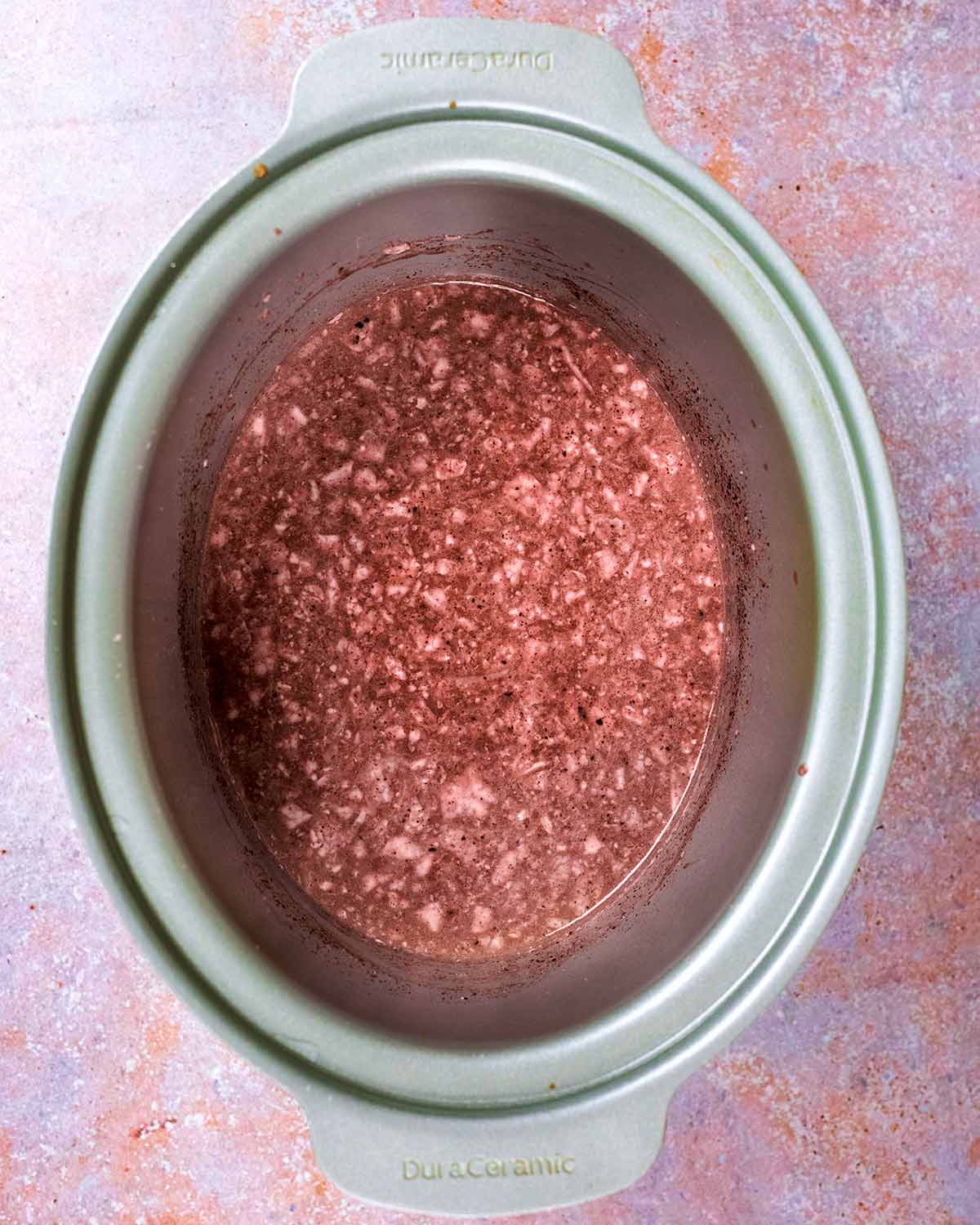 A slow cooker bowl containing hot chocolate.