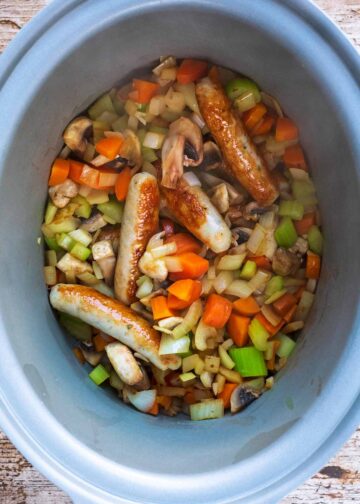 Sausages and chopped vegetables in a slow cooker.