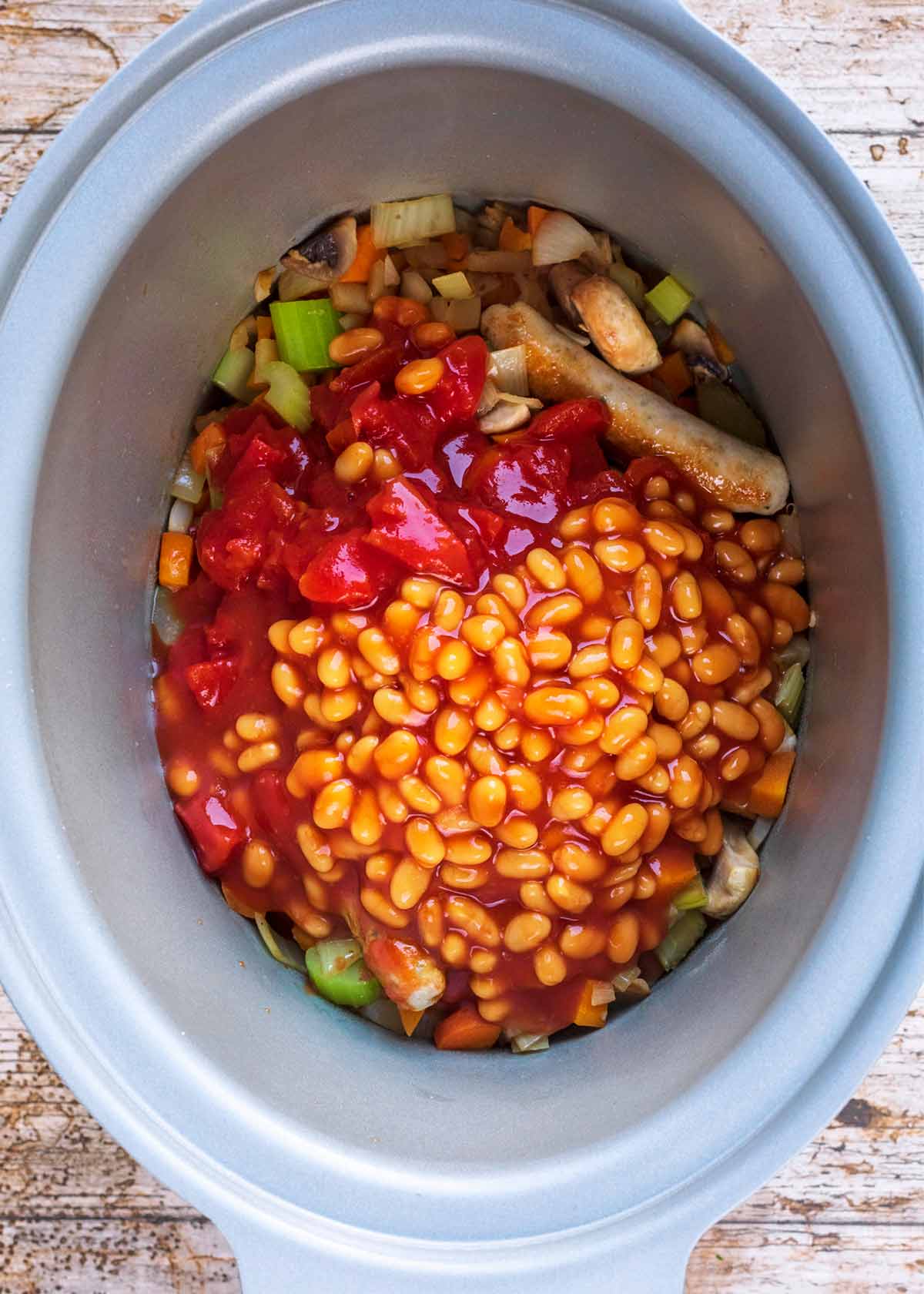 Chopped tomatoes and baked beans added to the slow cooker.