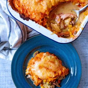 Turkey pie in a baking dish and some on a blue plate.