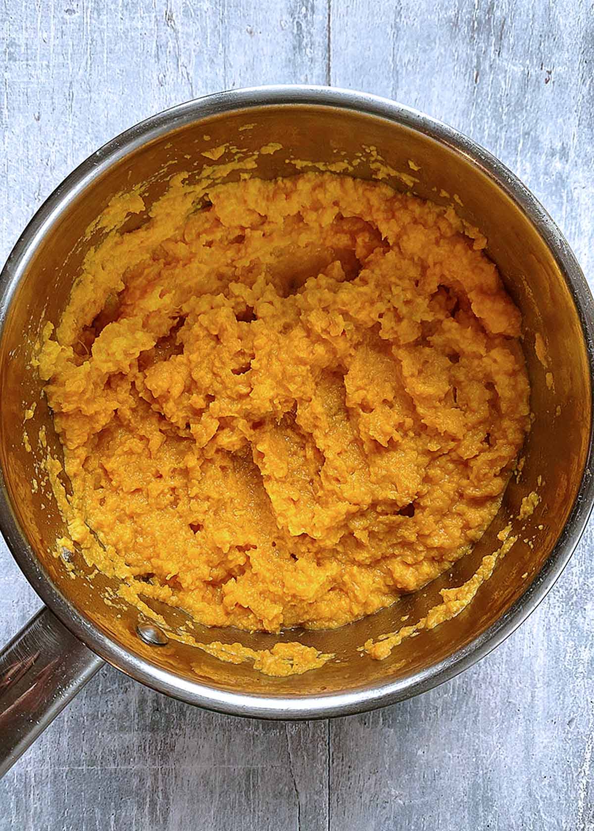 A saucepan full of mashed sweet potato.