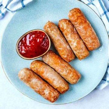 Air Fryer Sausages on a round blue plate.