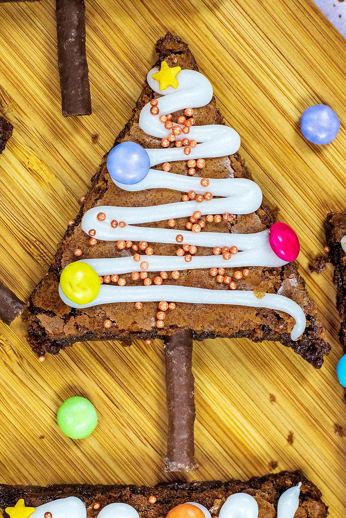 A triangular chocolate brownie decorated like a Christmas tree.