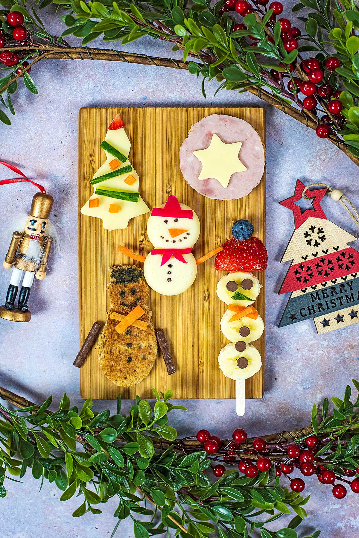 A wooden board covered in a variety of Christmas themed snacks.