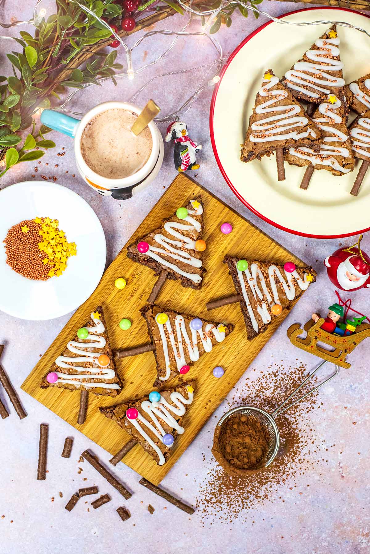 A wooden serving board with tree shaped brownies on it.