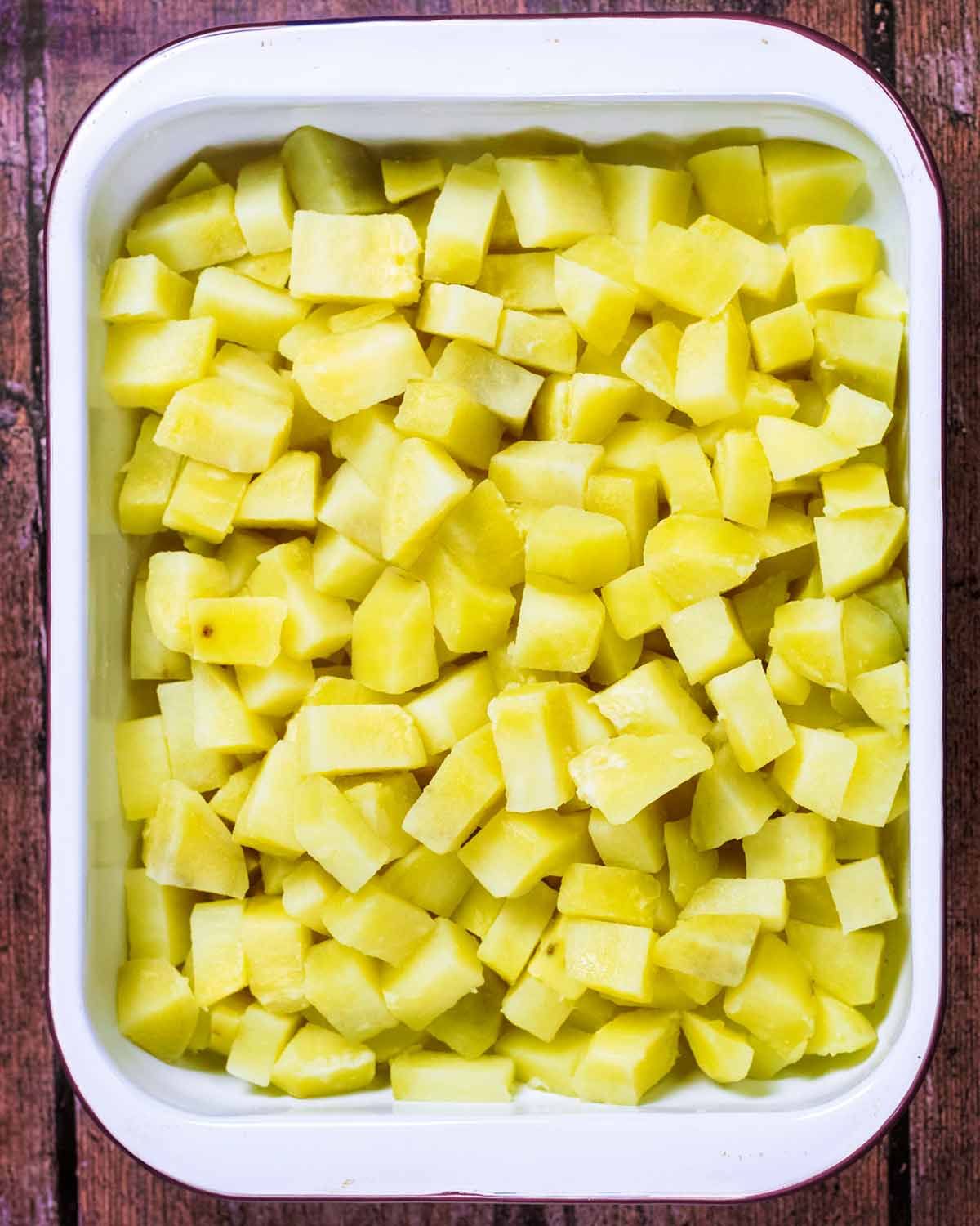 Cooked chopped potatoes in a rectangular baking dish.