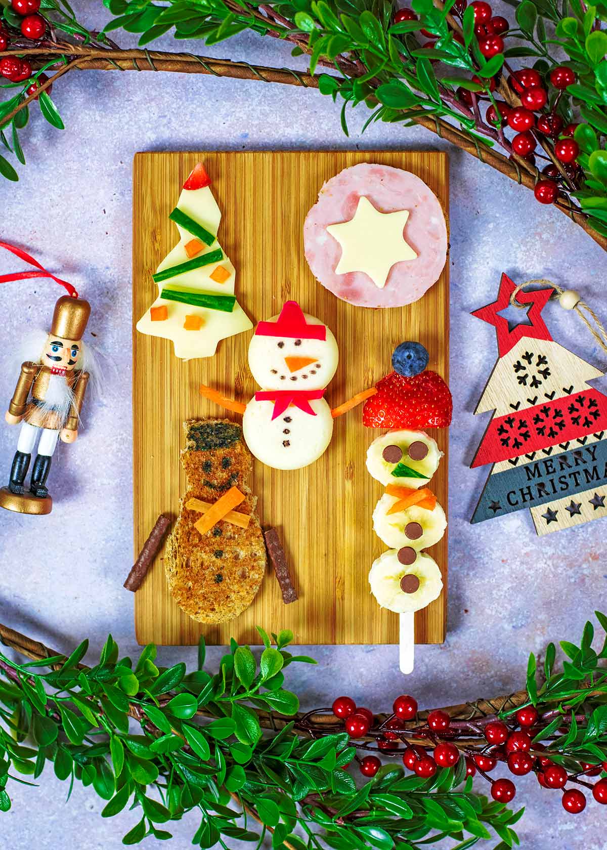 A wooden board covered in a variety of Christmas themed snacks.