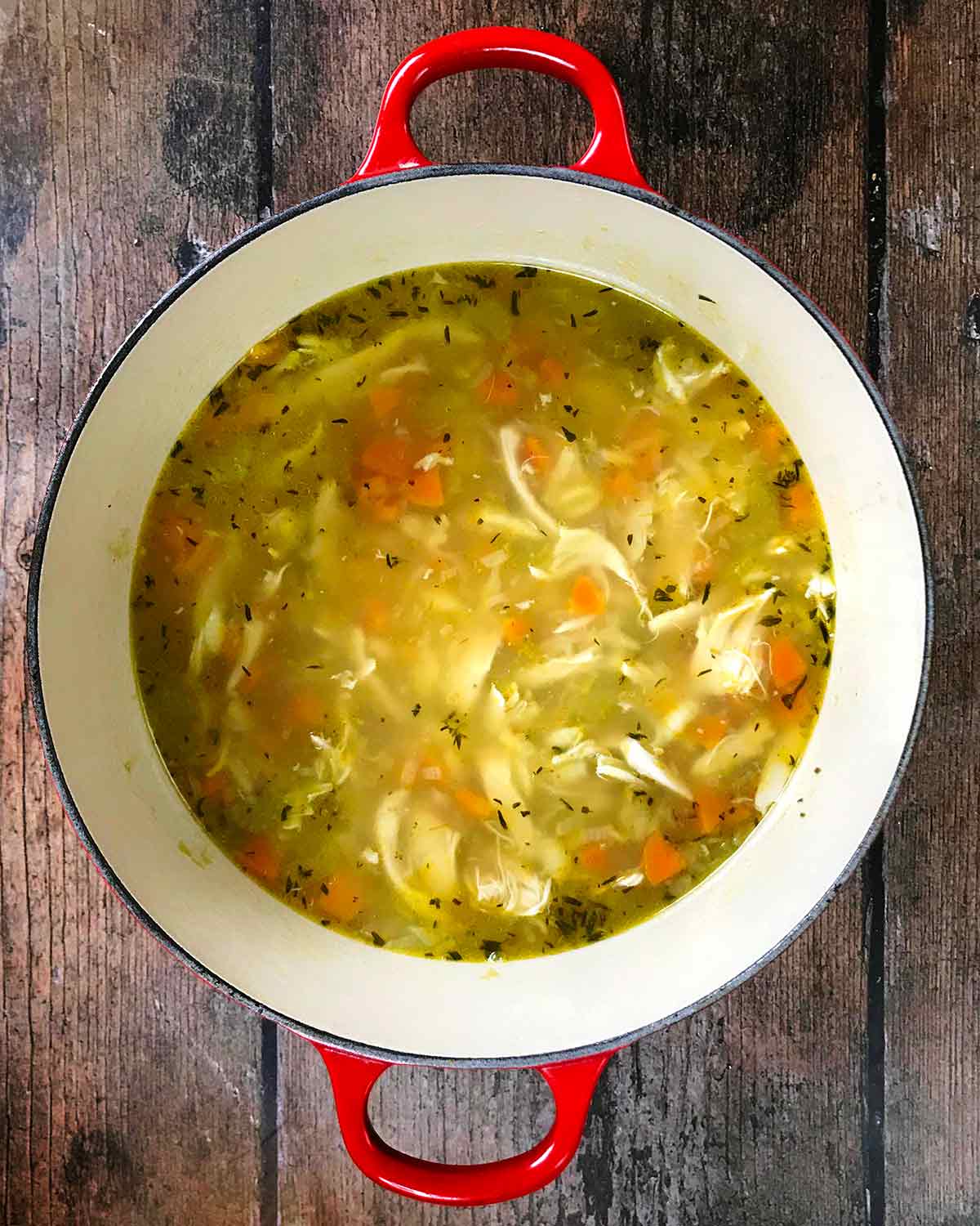 A large pan with cooked turkey soup in it.
