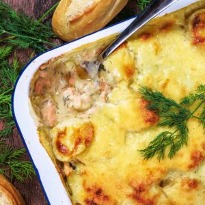 Salmon Casserole in a baking tin with a spoon removing a portion.