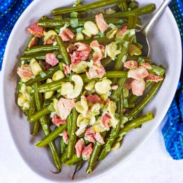 Slow cooker green beans in a bowl with a spoon.