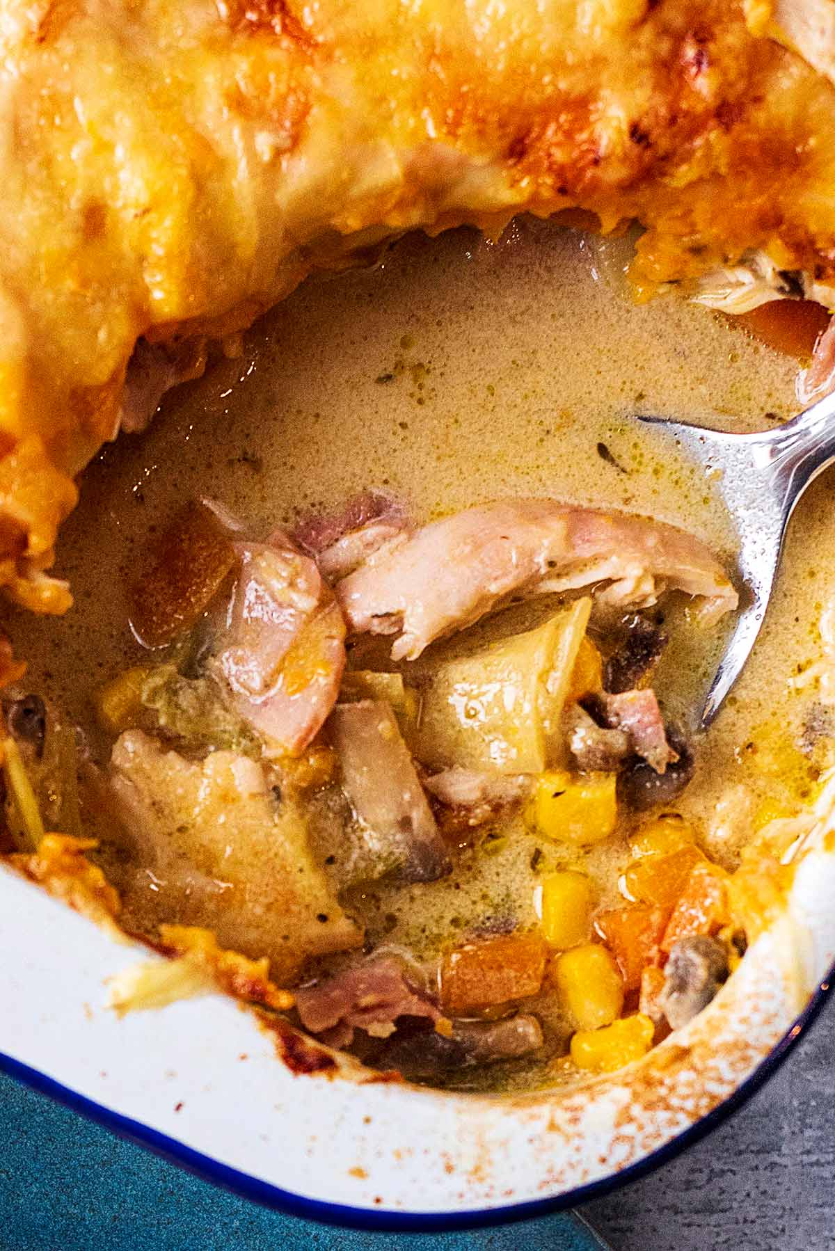 A spoon scooping out some pie from a baking dish.