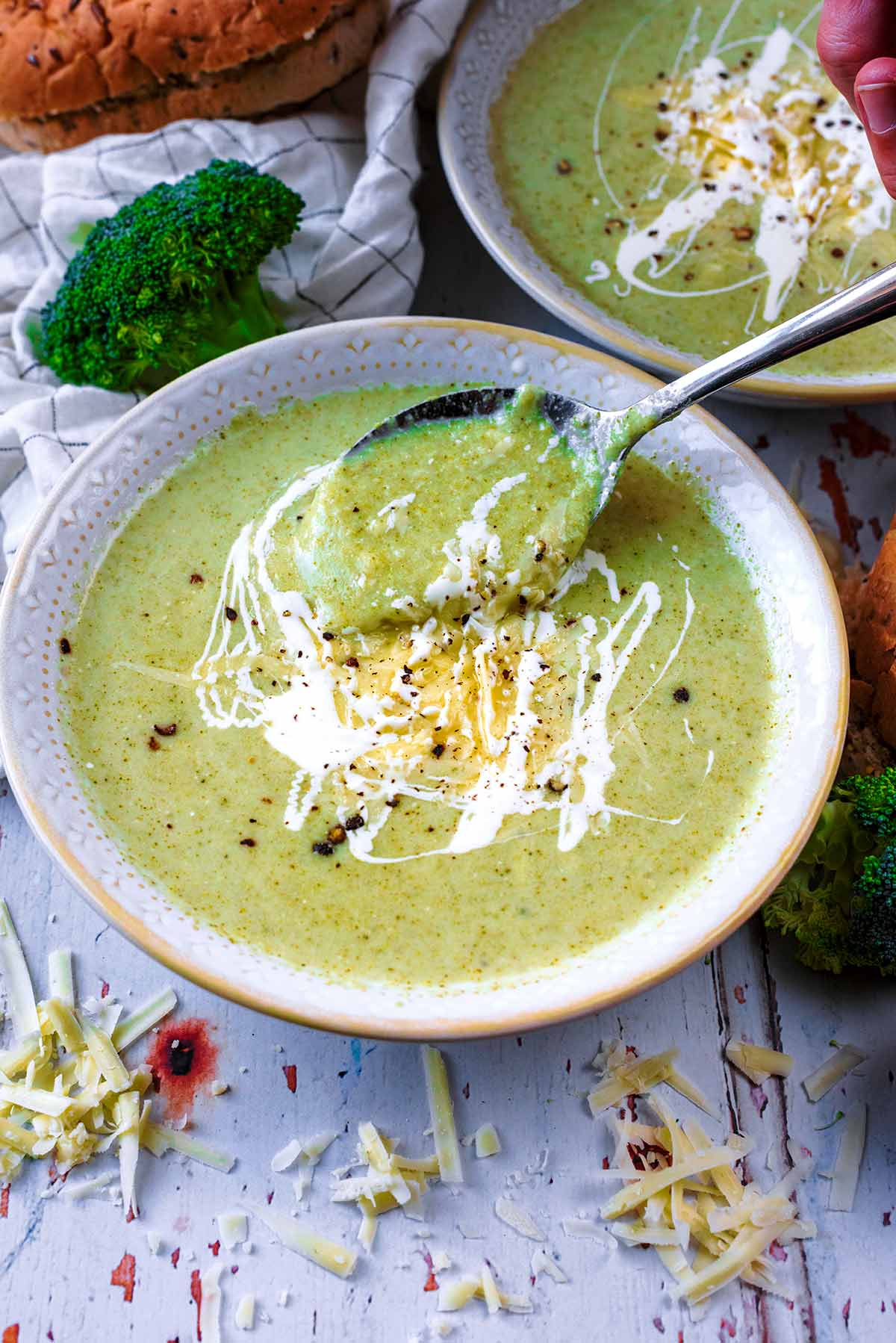 A spoon lifting some soup out of a bowl.