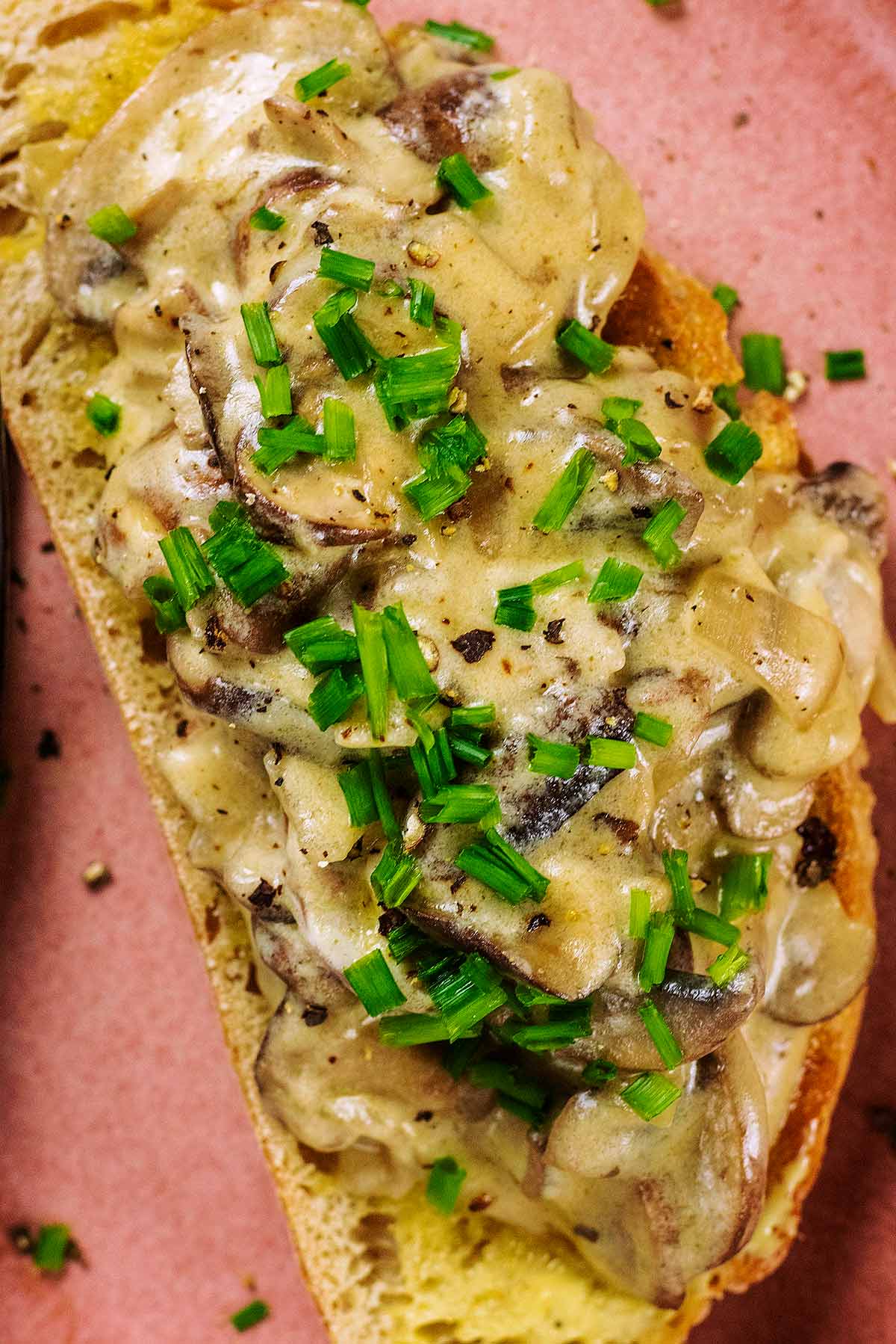 Chopped chives on top od mushrooms in a creamy sauce.