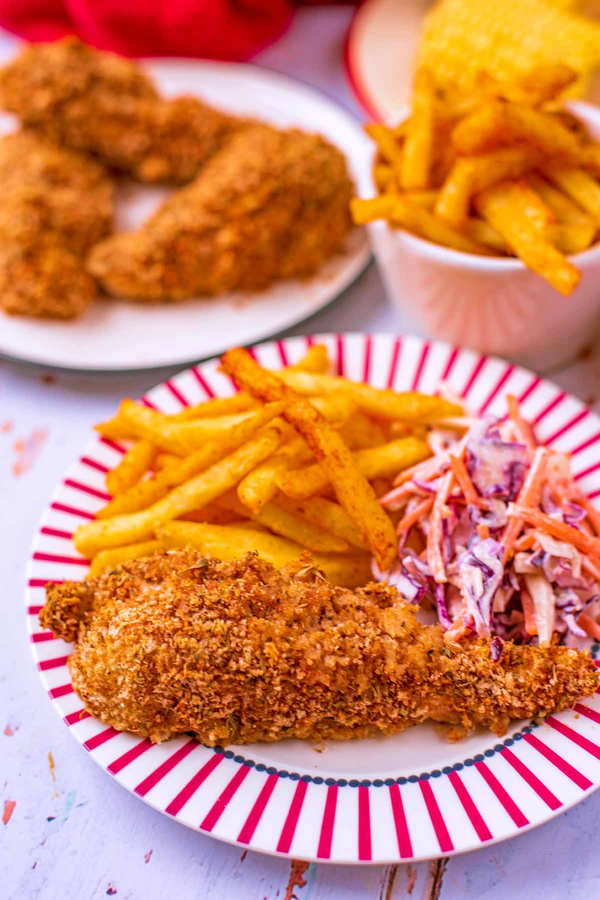 Healthy KFC on a red and white plate. French fries are in the background.