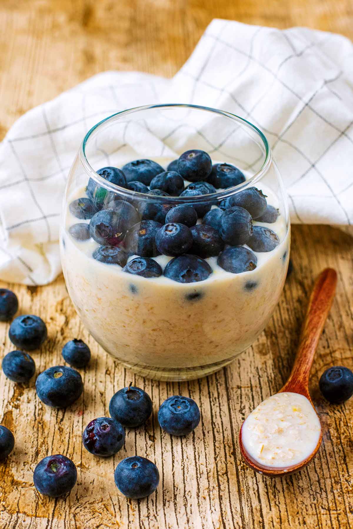 A glass of overnight oats topped with blueberries.