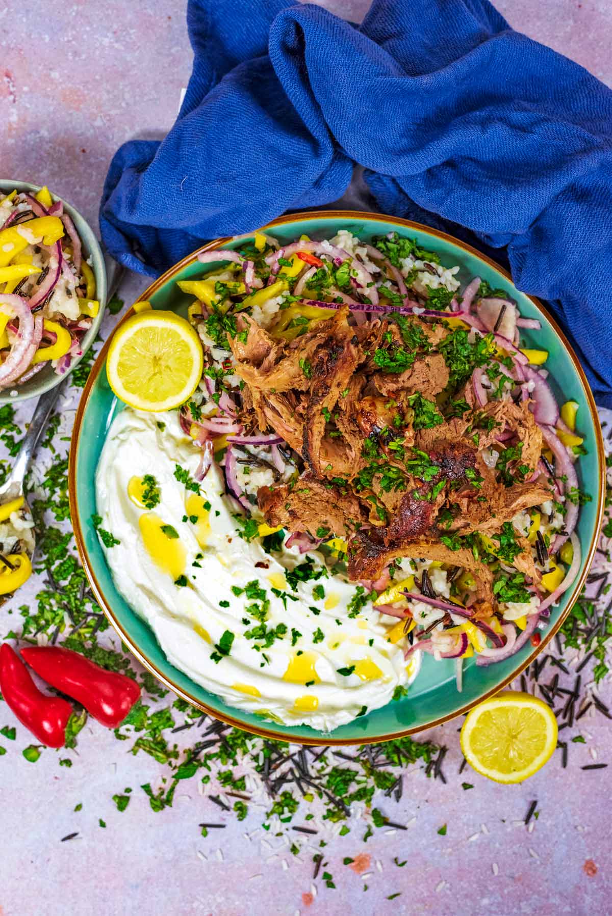 A plate of shredded lamb on a bed of rice with some Greek yogurt.