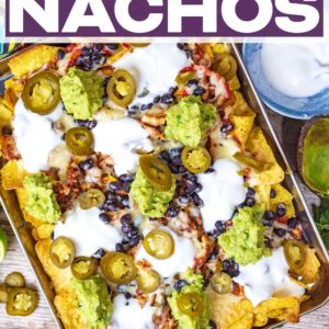 A tray of loaded chicken nachos with a text title overlay.