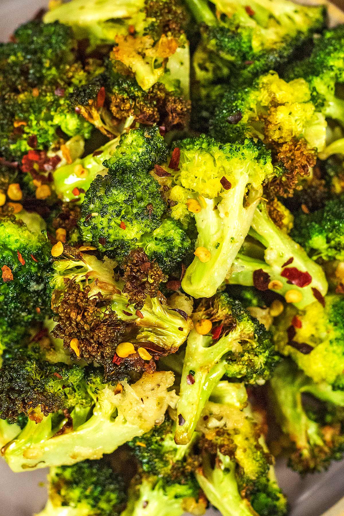 Cooked broccoli florets with chilli flakes sprinkled over them.