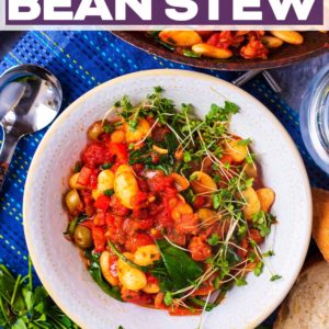 A bowl of Spanish bean stew with a text title overlay.