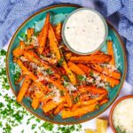 Air fryer carrot on a plate with a small bowl of creamy dip.