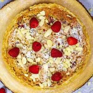 Bakewell pudding topped with icing sugar, fresh raspberries and flaked almonds.