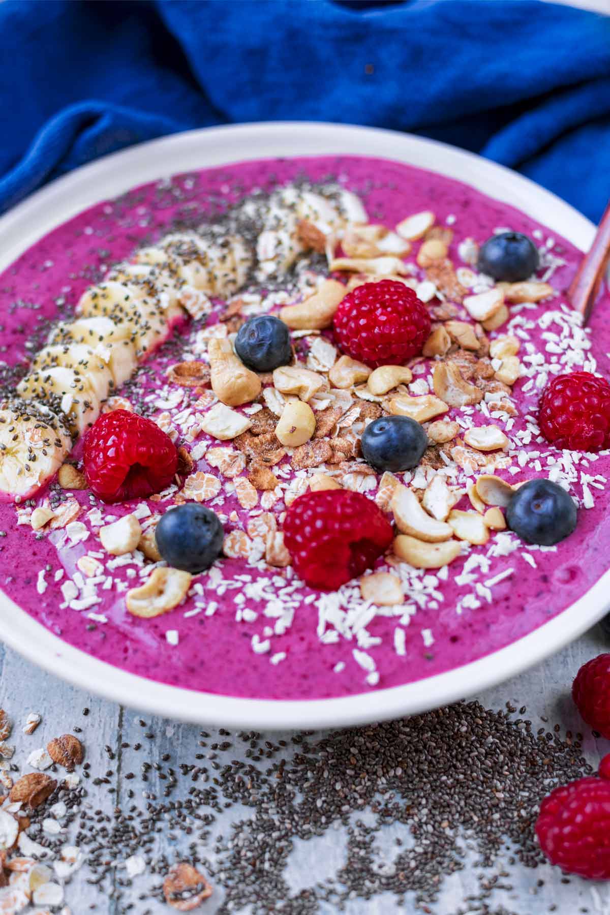 a bowl full of purple smoothie with a small wooden spoon.