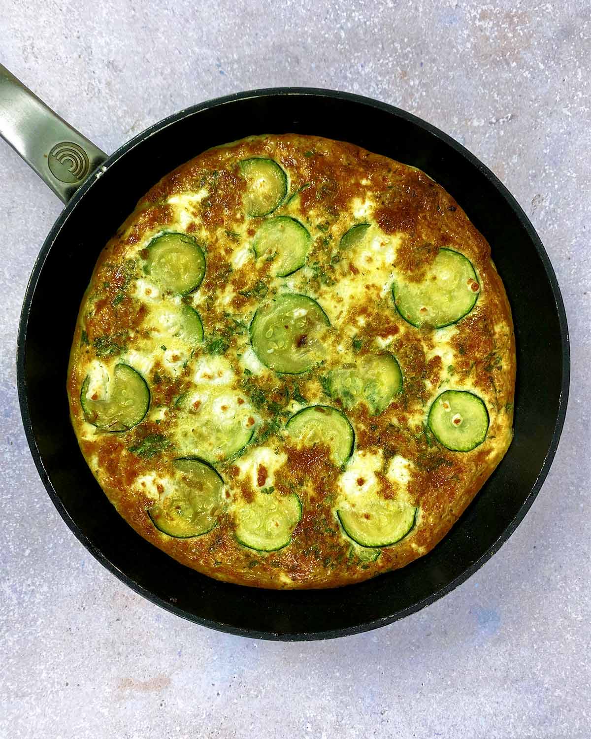 Cooked and browned frittata in a pan.