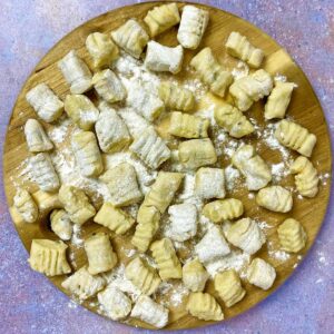 Leftover mashed potato gnocchi on a wooden serving board.