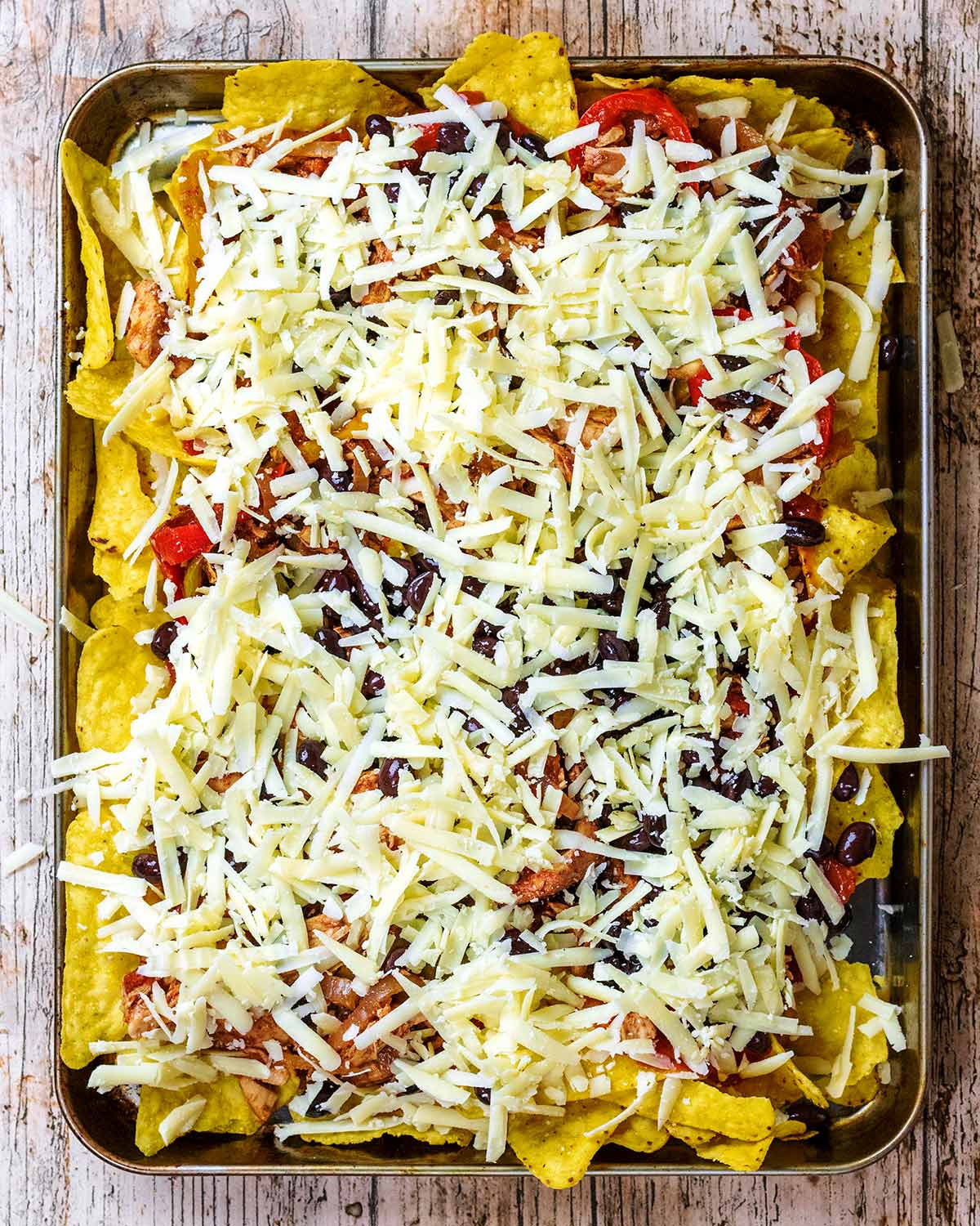 Grated cheese spread all over the nachos.