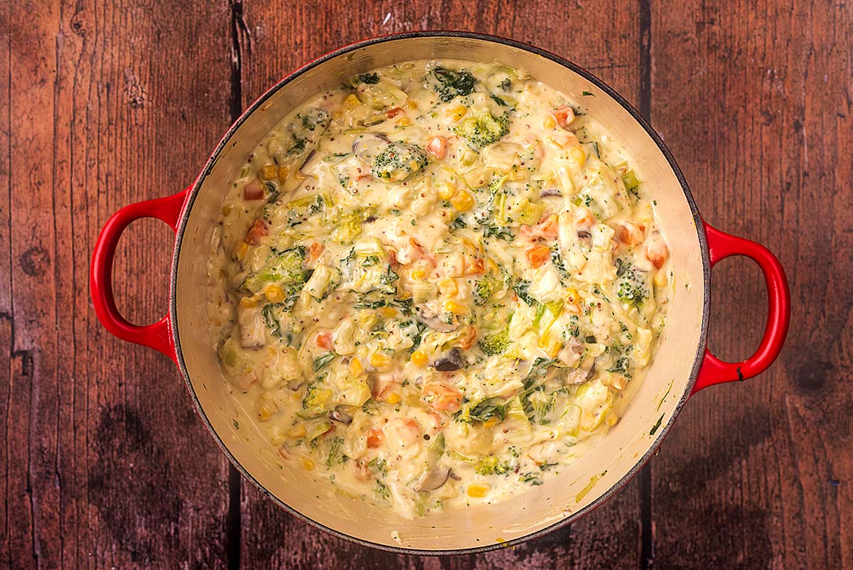 A large cooking pot with chopped cooked vegetables in a creamy sauce.