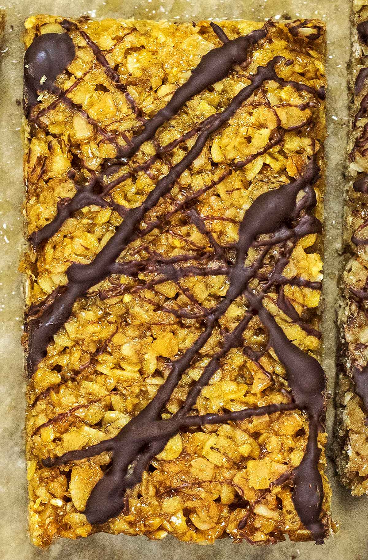 A flapjack with a random pattern of drizzled chocolate.