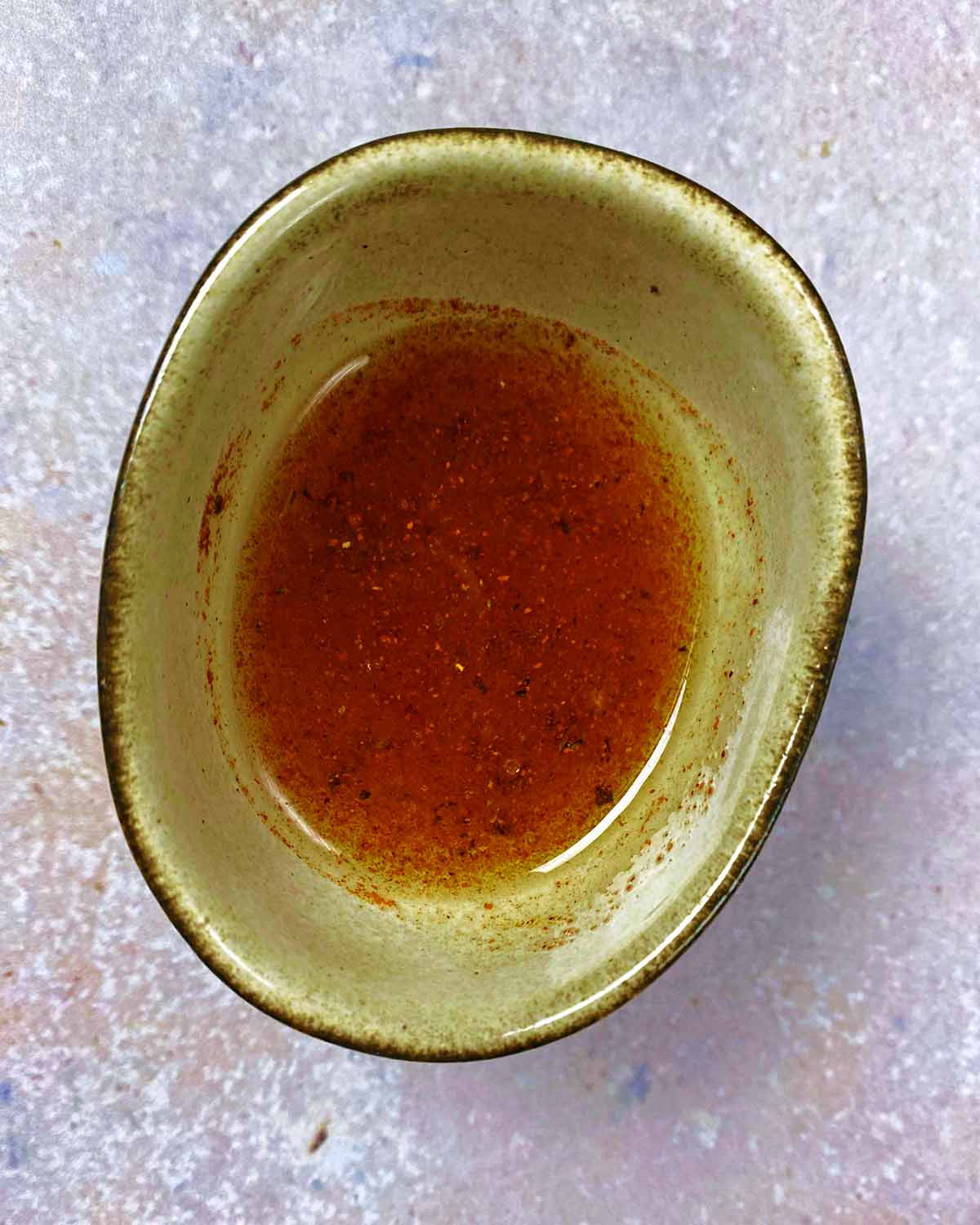 Paprika and oil in a bowl mixed together.