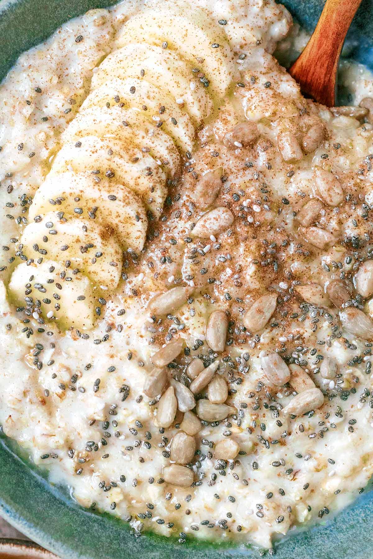 Slices of banana and seeds on top of cooked porridge.