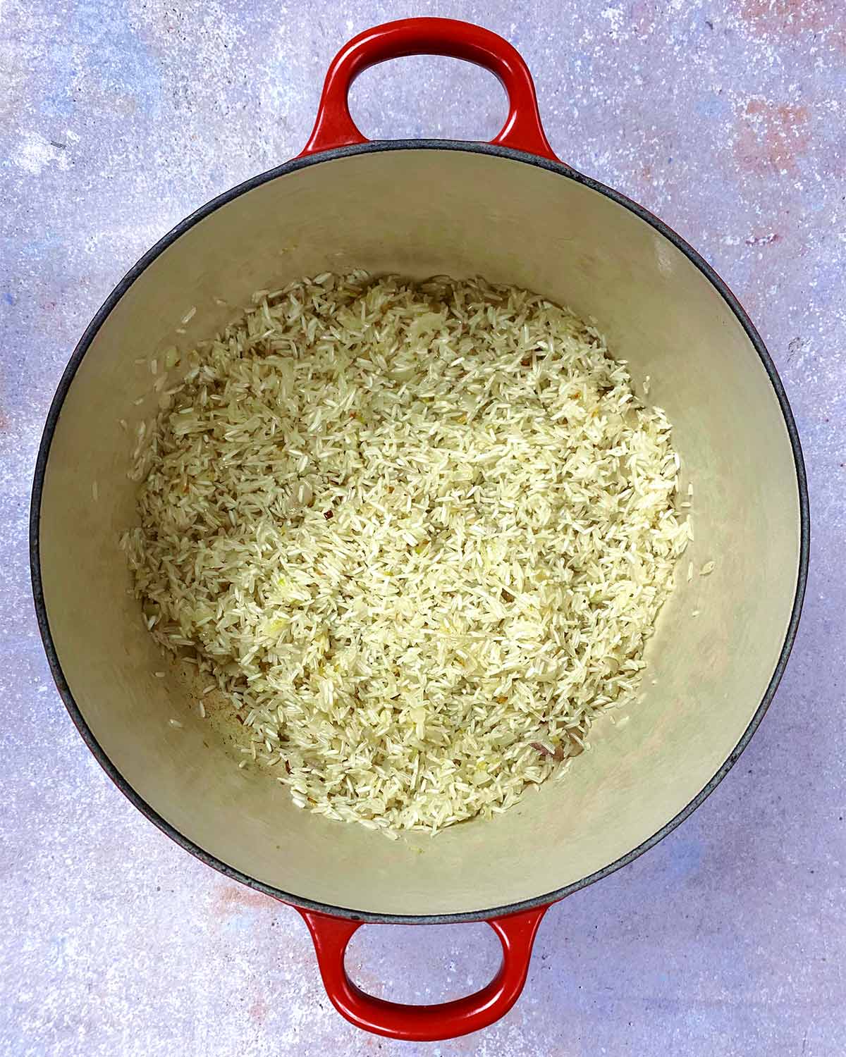 Part cooked rice in the pan.