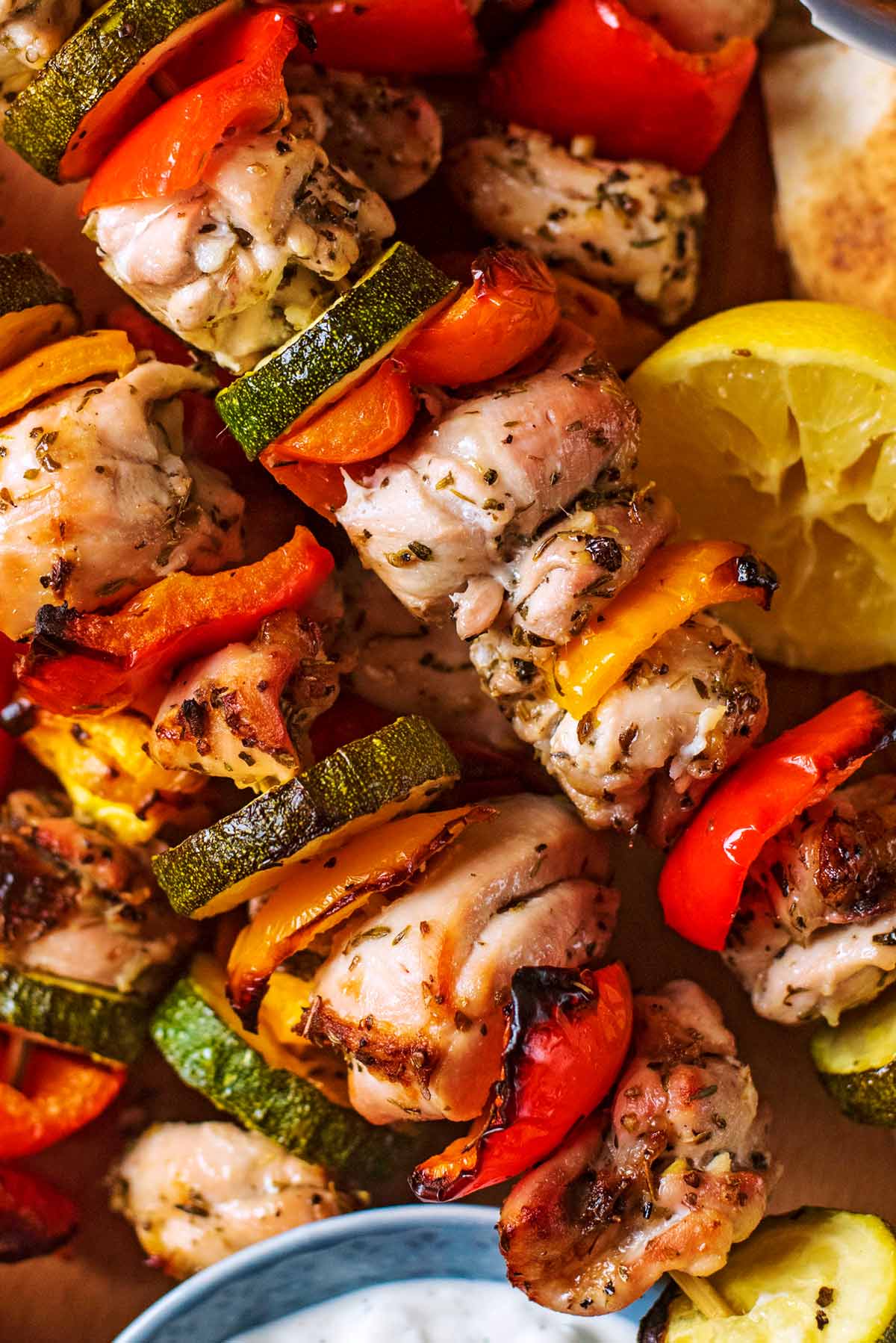 Chunks of cooked chicken and sliced vegetables together on skewers.