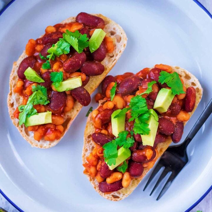Two slices of Mexican Beans on sourdough toast, topped with avocado