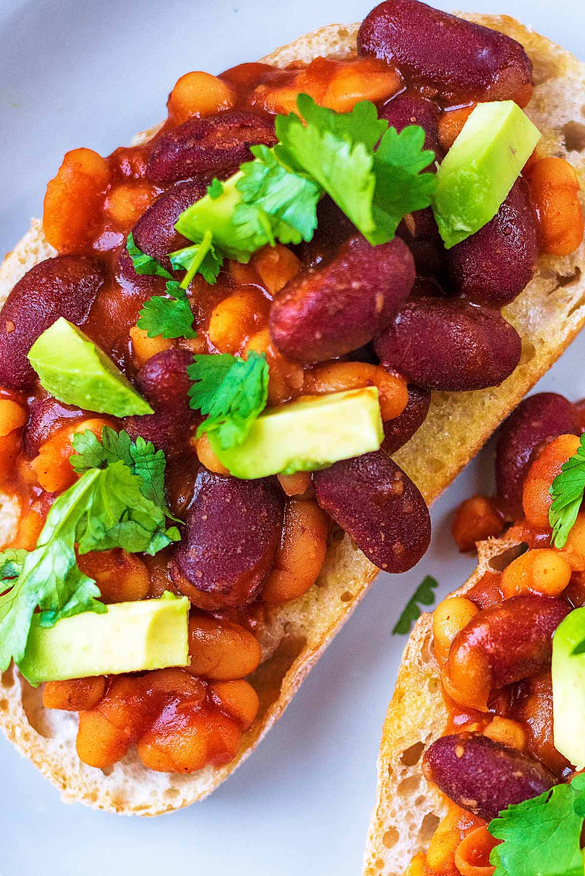 Cannellini and red kidney beans in a tomato sauce on top of toast.